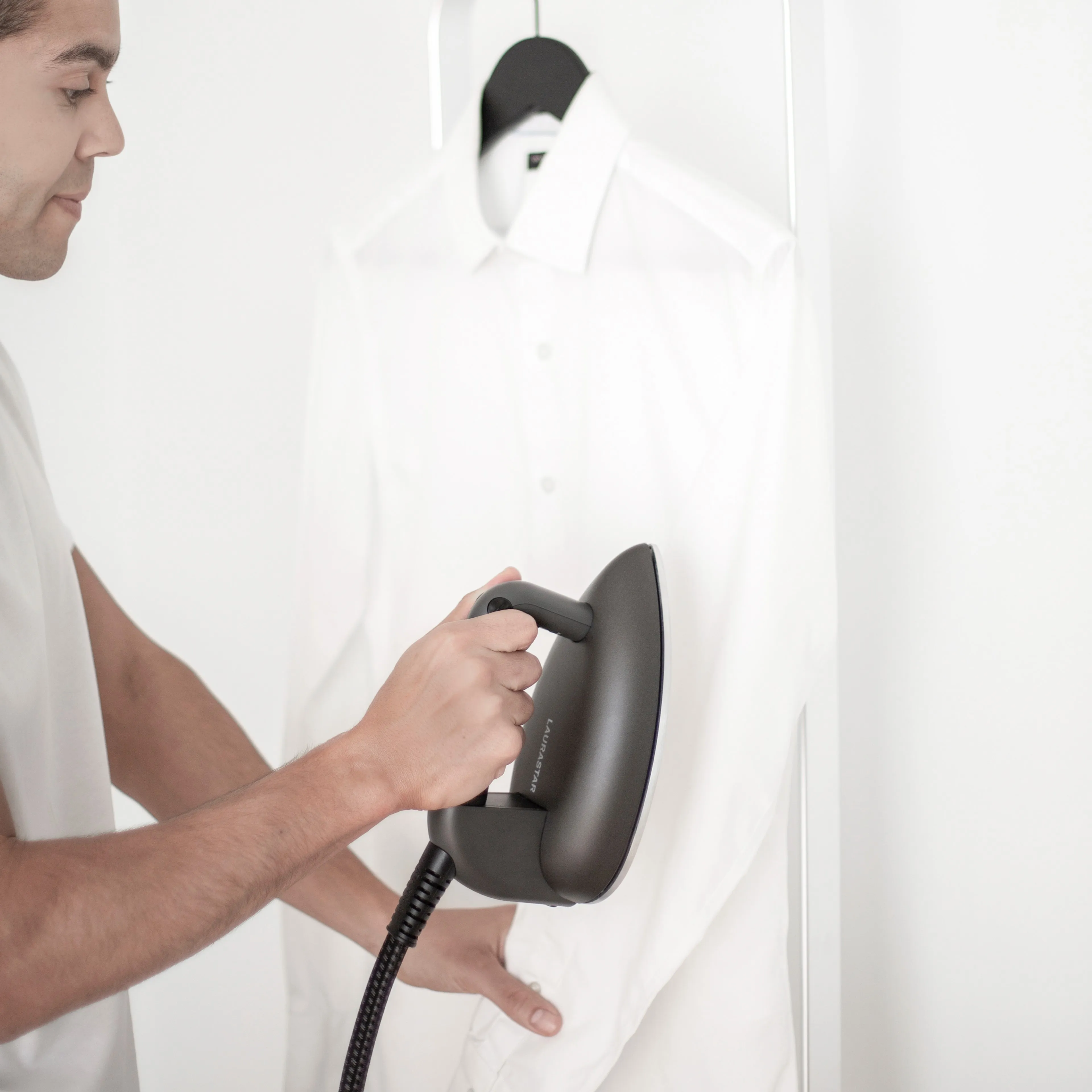 A close-up overhead shot of a neatly ironed dress shirt laid flat on a Laurastar active ironing board, fabric perfectly smooth and crease-free, representing the result of ActivAir technology, vacuum function and professional steam ironing for luxury laundry care.