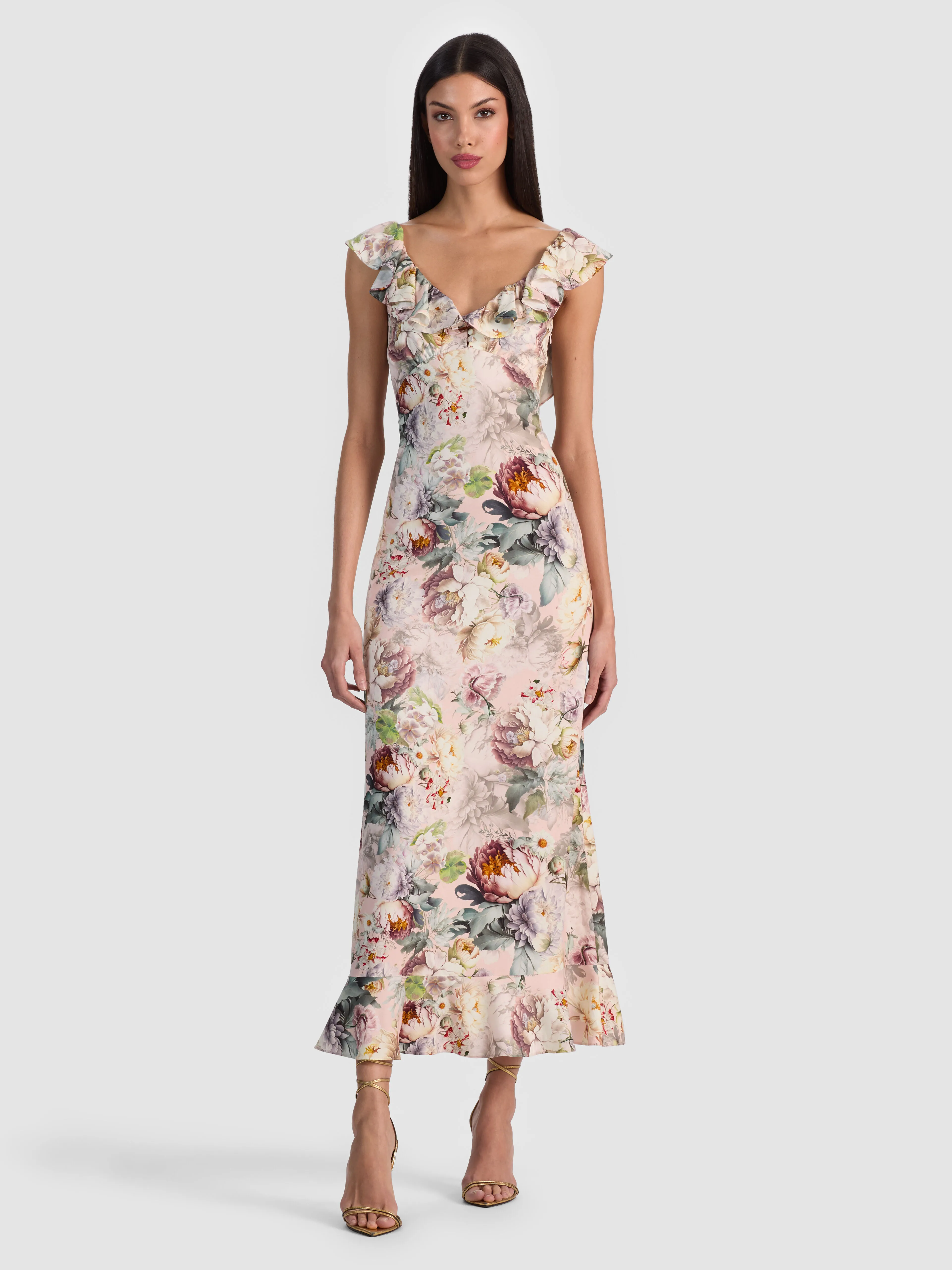 A model wearing the ALICE + OLIVIA Gemma Midi Dress — a floral printed rayon twill style with a ruffled sweetheart neckline and flowing silhouette — styled for an elegant occasion.