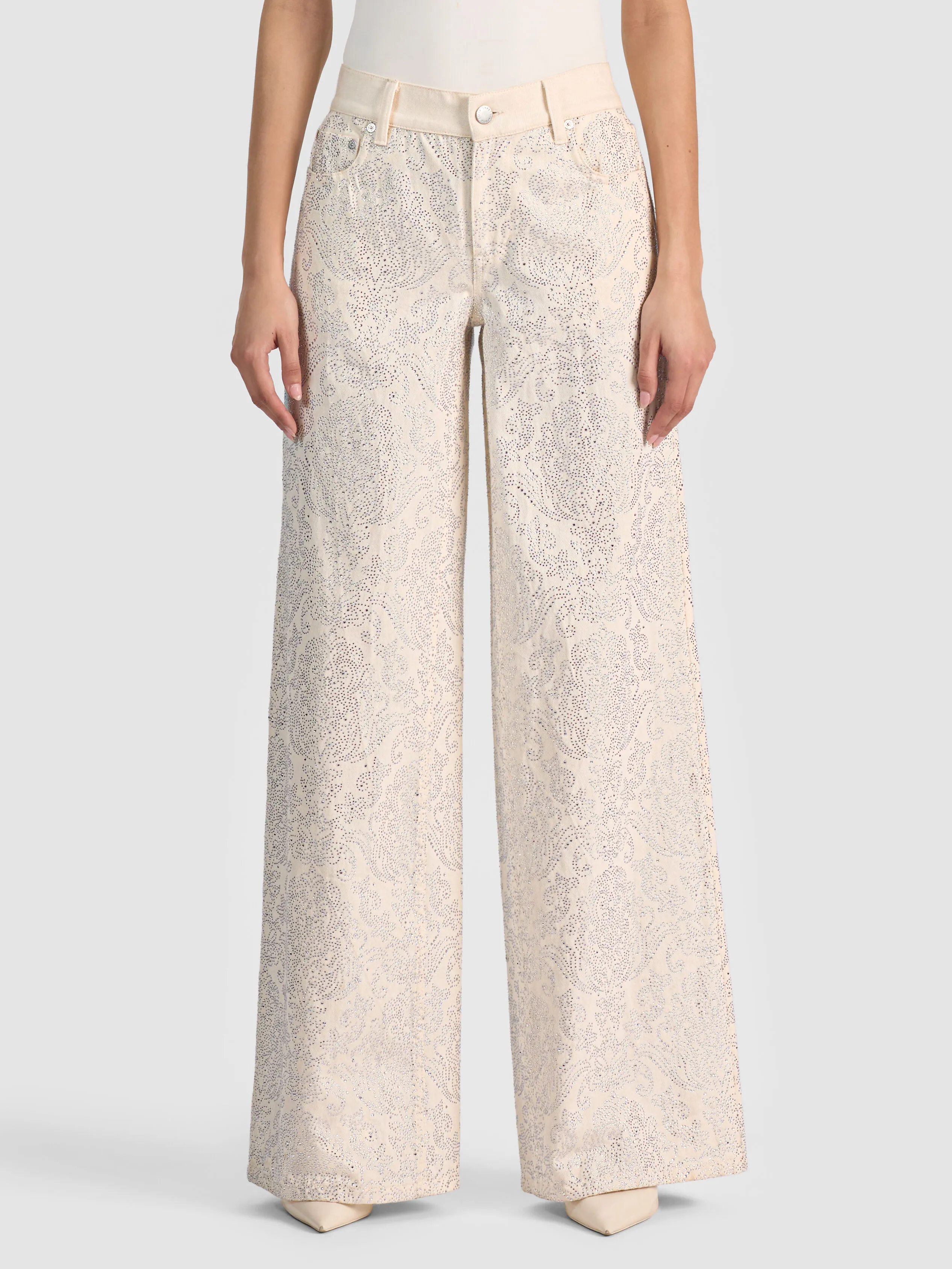 A woman wearing the ALICE + OLIVIA Amazing Embellished Jean with a crystal-embellished paisley print, illustrating the printed and statement denim trend for 2026.