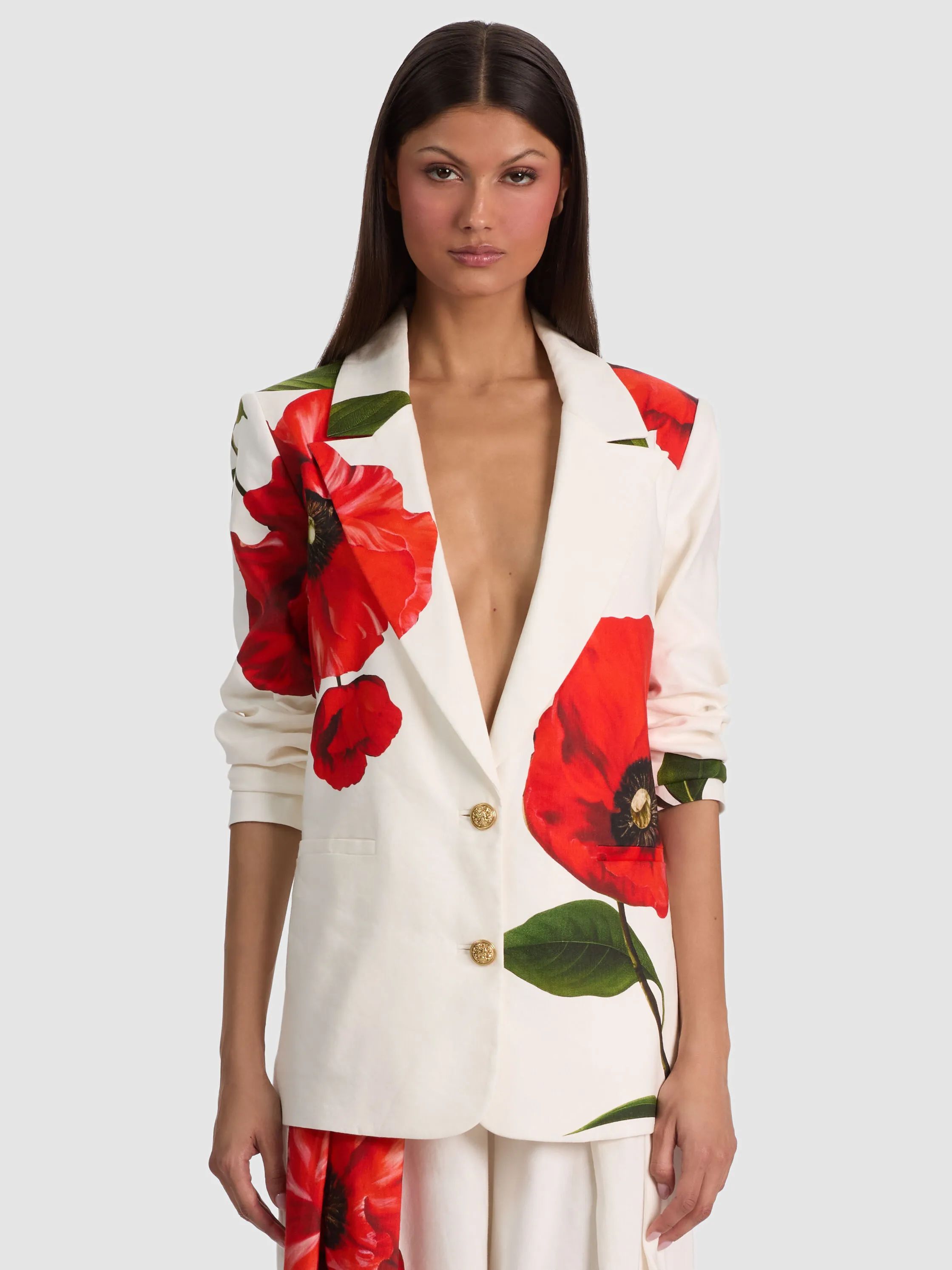 A woman wearing the ALICE + OLIVIA Elna Slim Long Blazer, styled with accessories including bold earrings and a structured handbag, demonstrating how the right finishing touches elevate a tailored suit look.