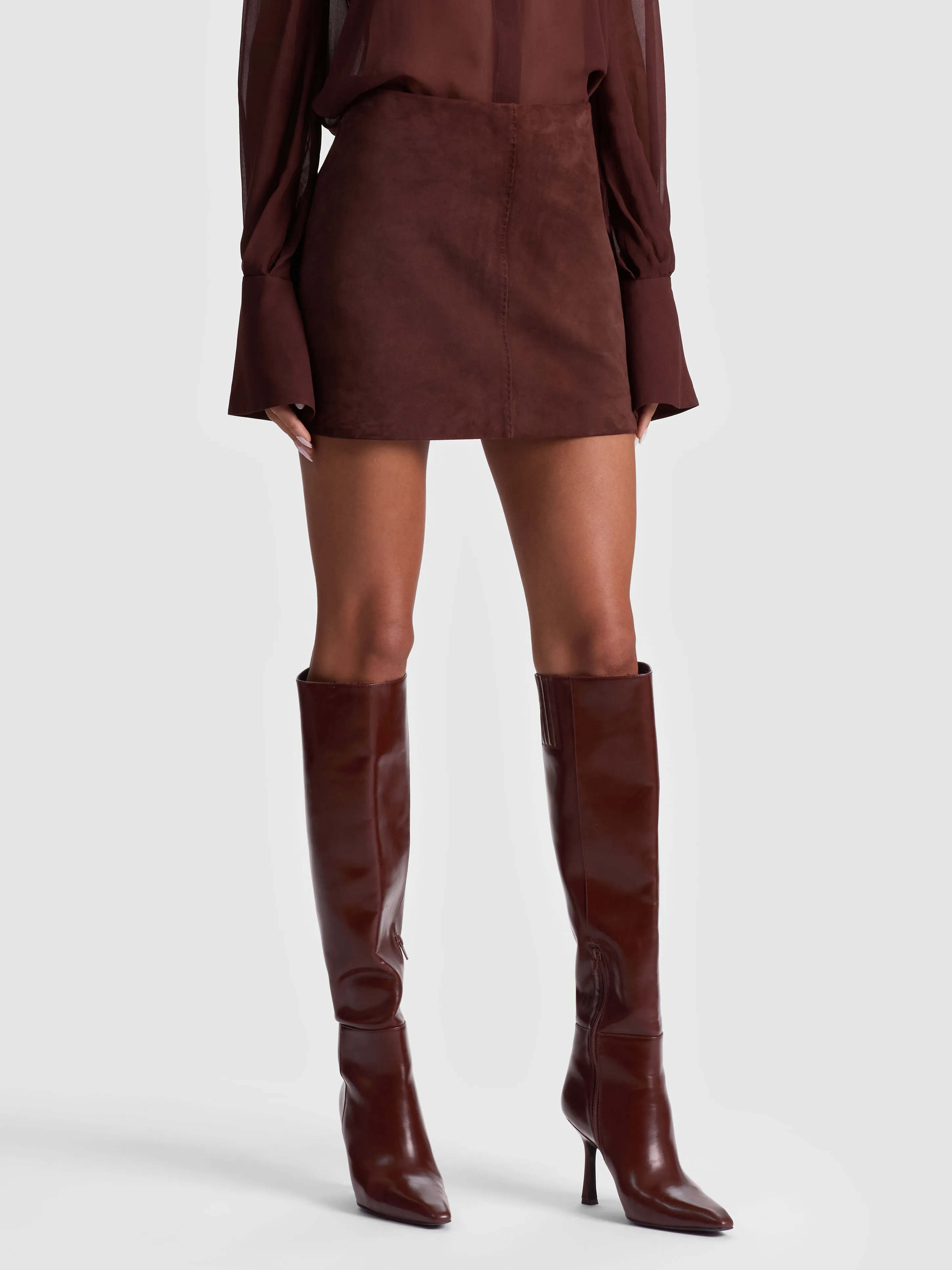 A sleek leather midi skirt paired with a structured blouse for an edgy and elevated evening look
