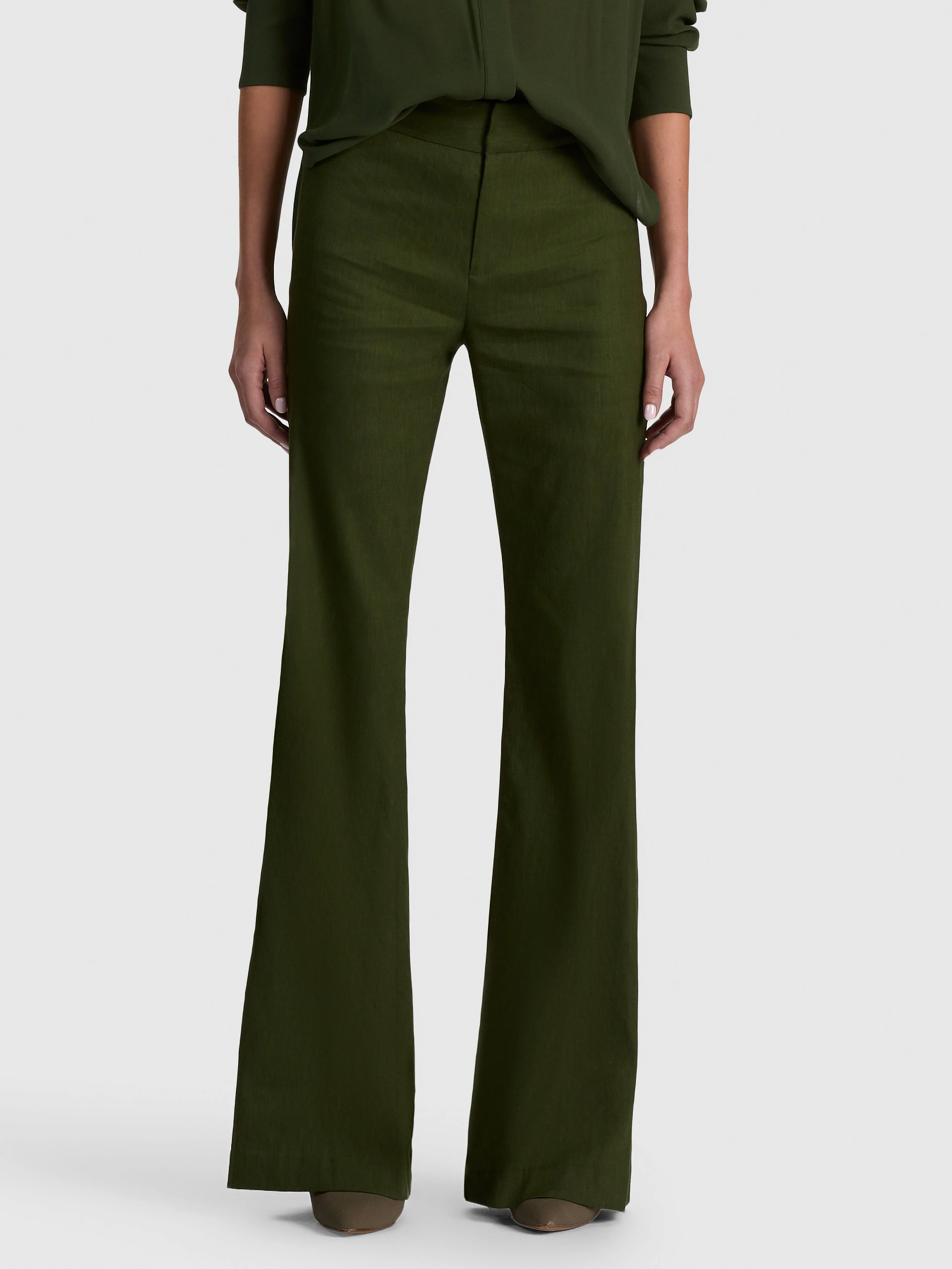 A model wearing the ALICE + OLIVIA Andrew Linen Pant in dark green, paired with the Breann Linen Blazer, demonstrating a polished, high-rise bootcut silhouette in a matching suit set.