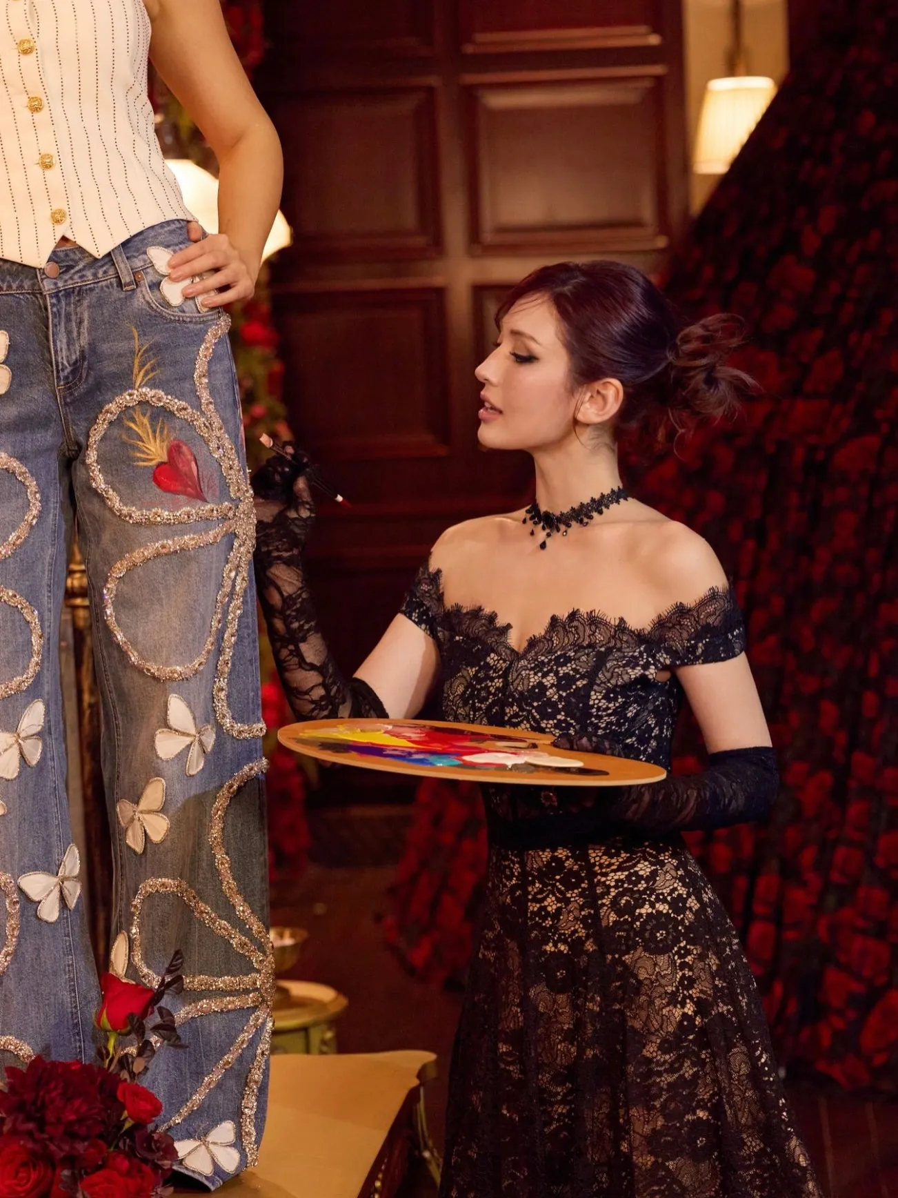A close-up shot of a black textured cardigan adorned with colorful embellished flowers and gold rose-shaped buttons.