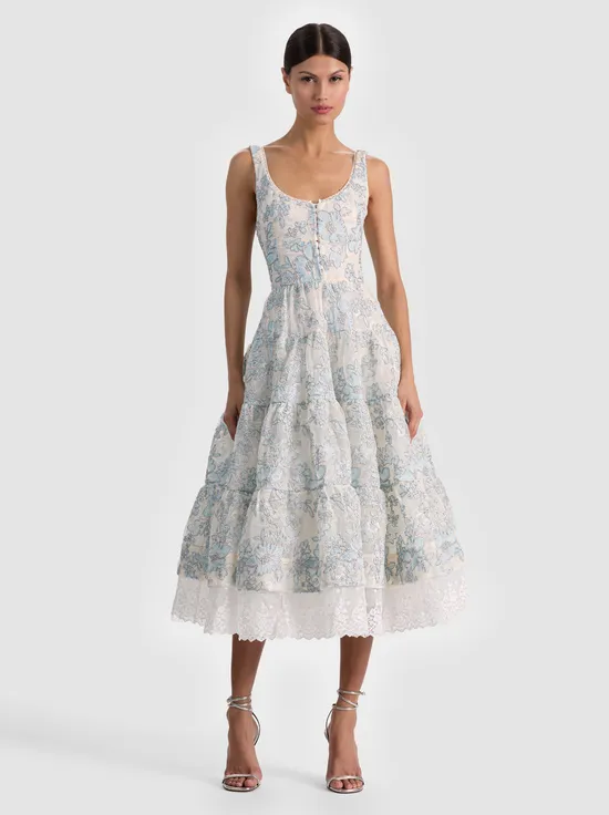 A model wearing a streamlined sleeveless dress that highlights the arms and shoulders, styled for a summer day or office setting