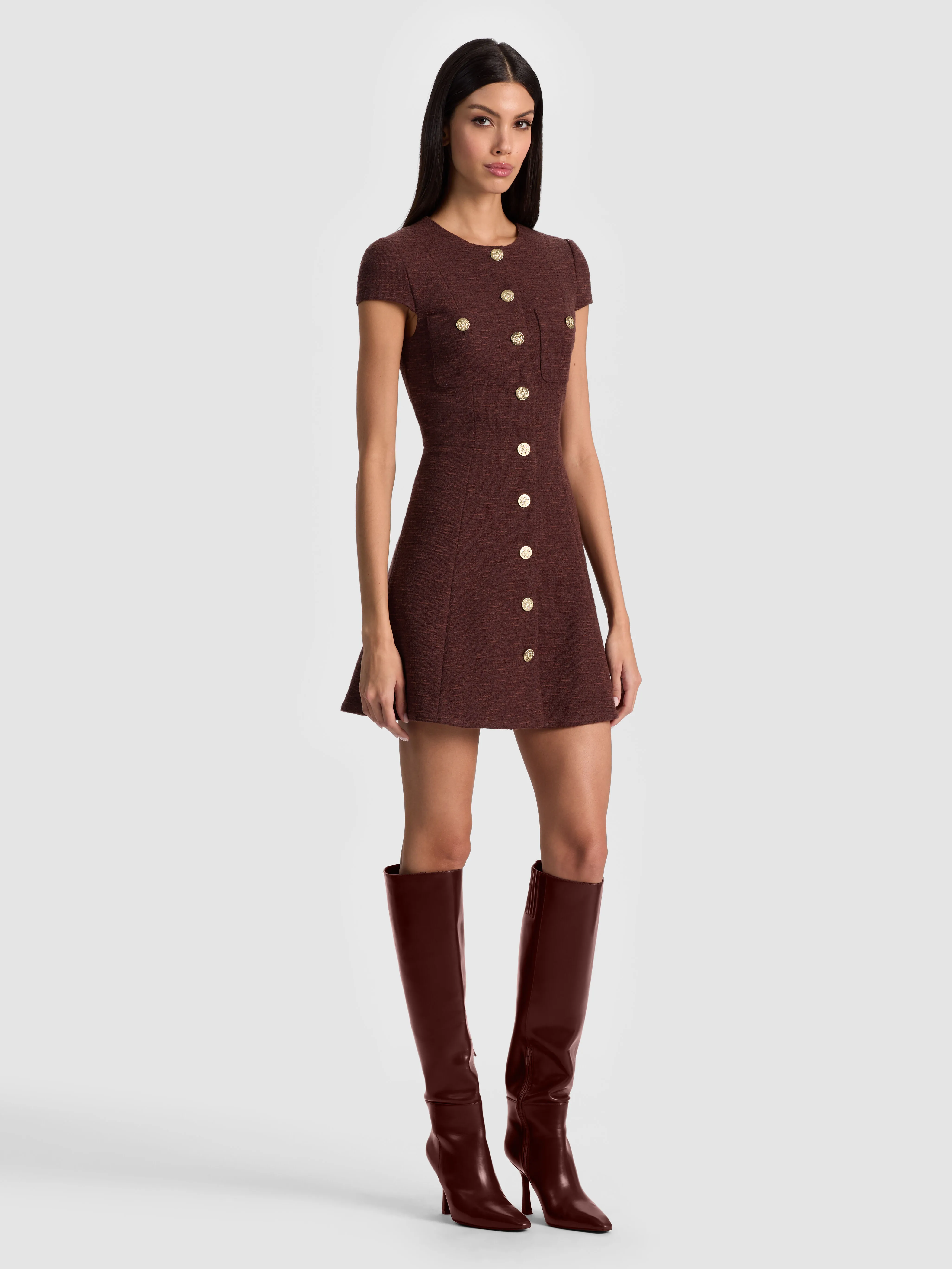 A model wearing a delicate cap sleeve dress with small rounded sleeves that just cover the tops of the shoulders, perfect for semi-formal occasions