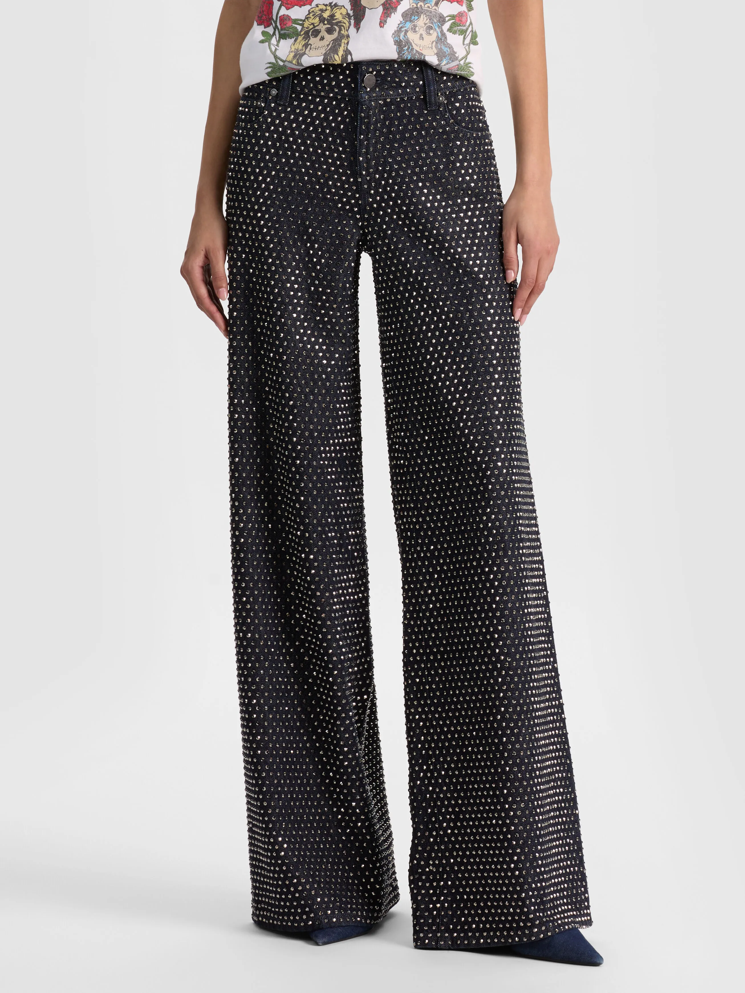 A woman wearing the ALICE + OLIVIA Amazing Embellished Jean in a luxurious dark-rinse wash, representing the dark-wash refinement denim trend for 2026.
