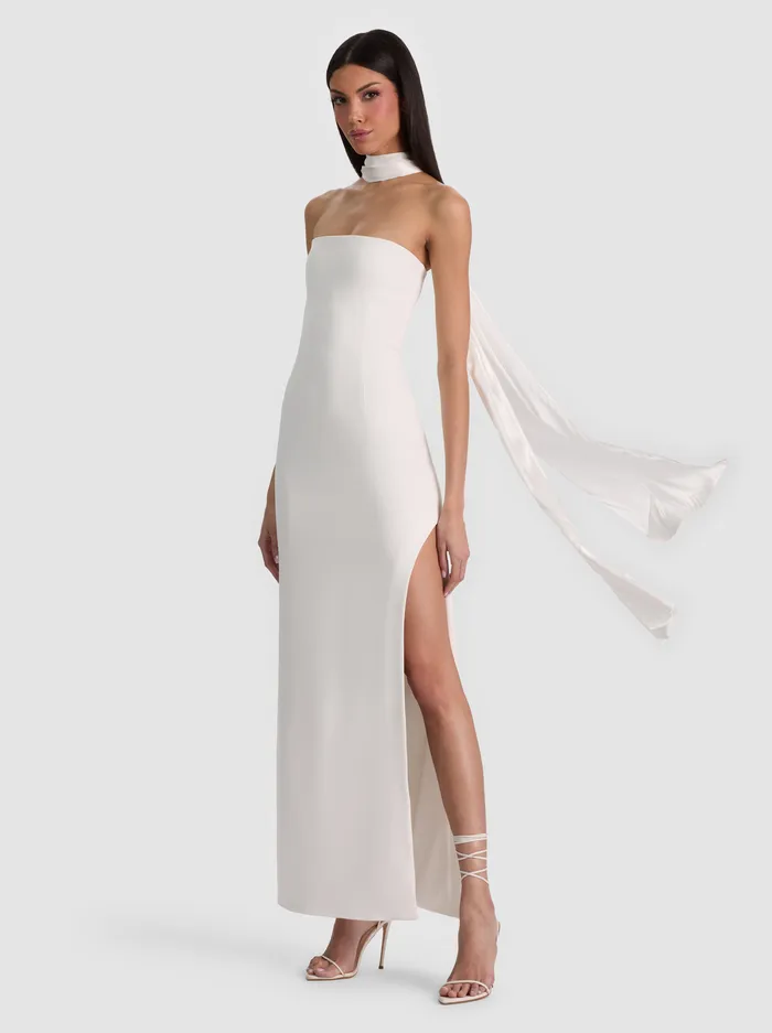 The ALICE + OLIVIA CHANA MAXI DRESS WITH SCARF in Off White — a strapless bodycon maxi with a detachable neck scarf and high side slit, styled over a turtleneck with tall boots and a long coat for a chic winter holiday event.