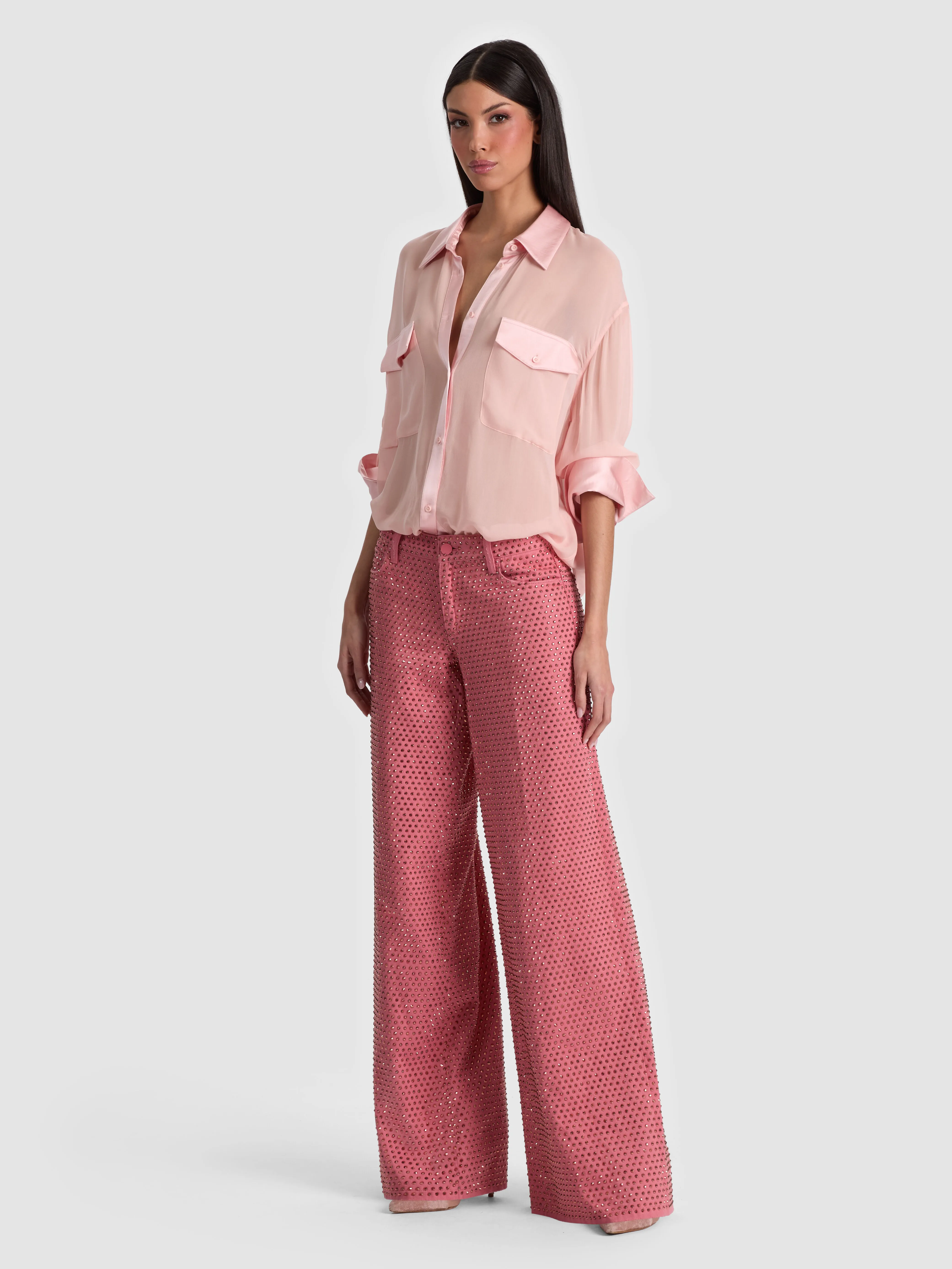 Full-body head-to-toe shot of a model wearing the ALICE + OLIVIA Amazing Embellished Jean in Deep Rose/Rose Gold, styled for an evening out with heels and a statement earring.