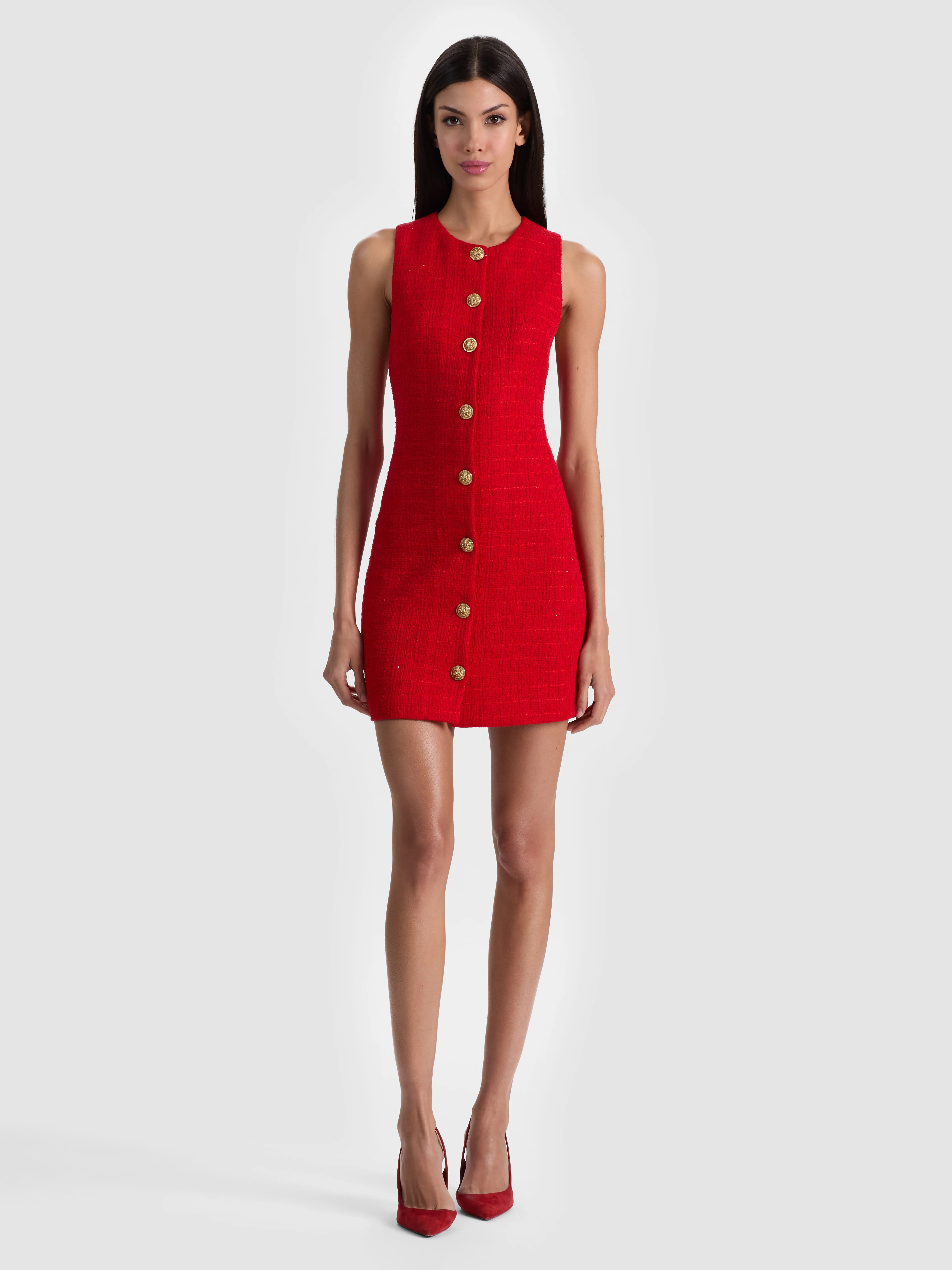 A model wearing a straight, boxy shift dress falling loosely from the shoulders in a sleek mod-inspired style