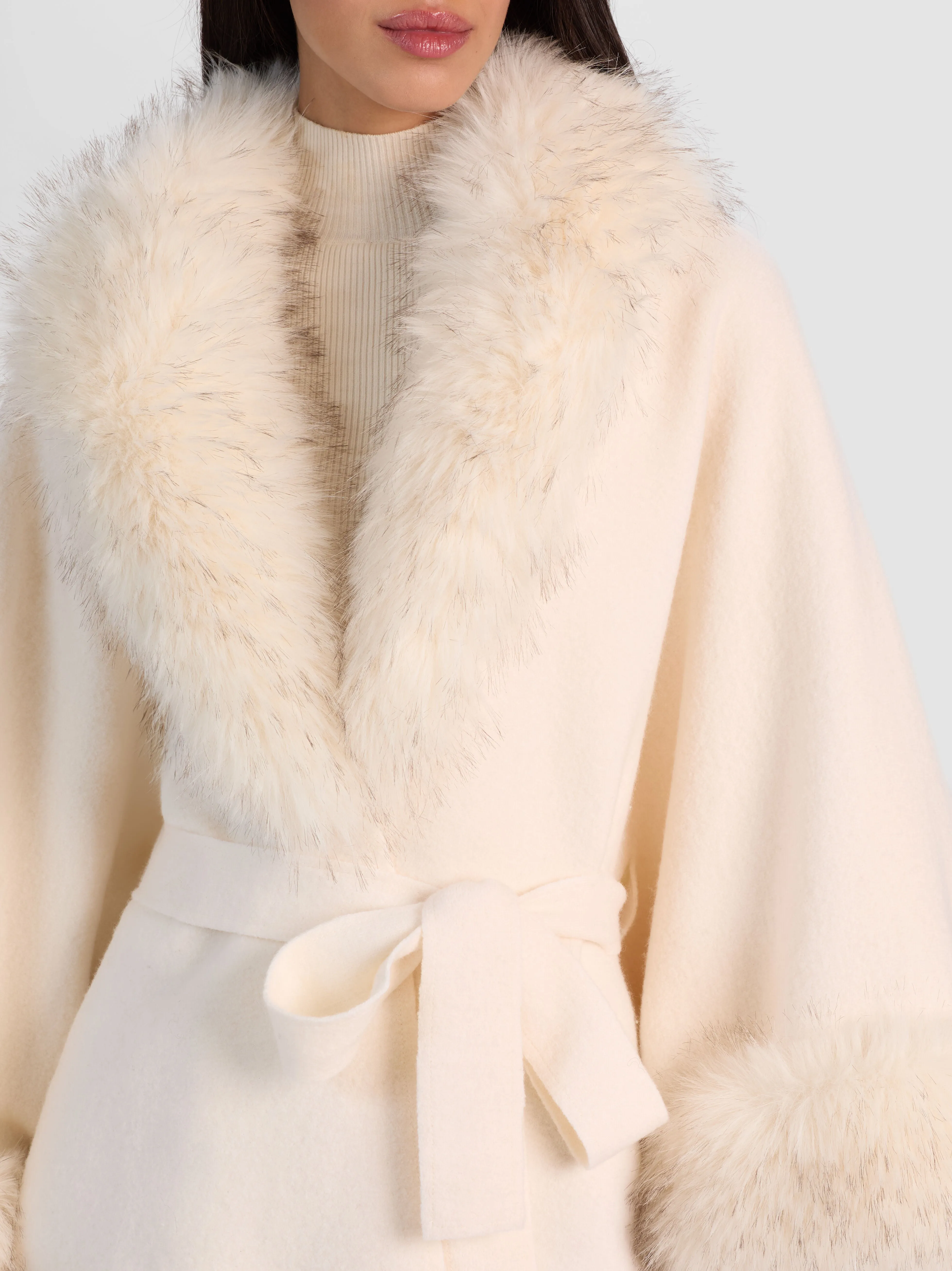 ALICE + OLIVIA Joanne Sweater Coat in ecru wool with detachable faux fur trim, worn by Anastasia Gerrans at NYFW 2026