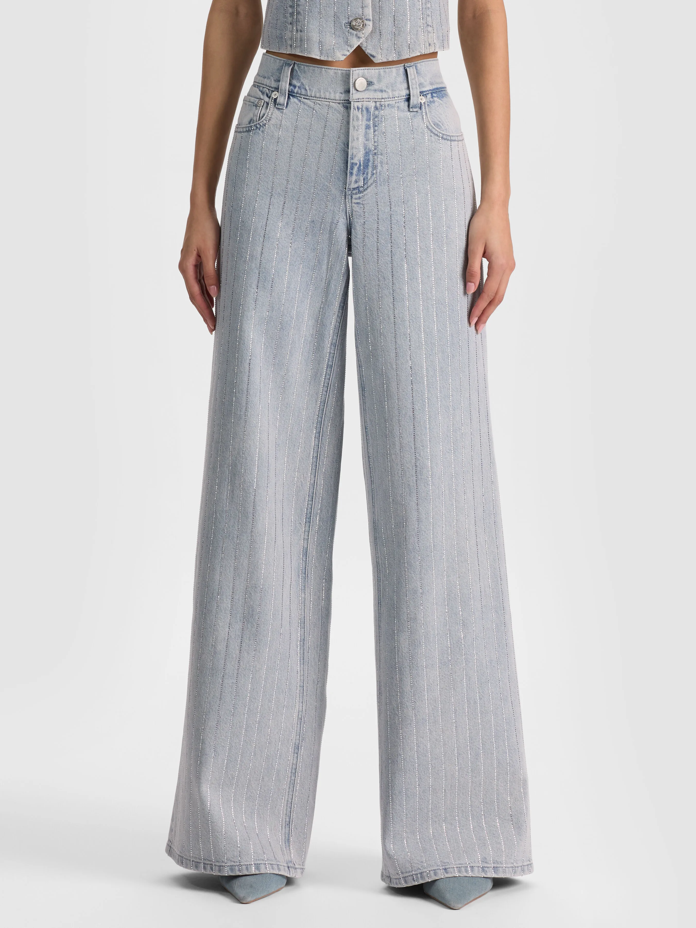 A woman wearing the ALICE + OLIVIA Amazing Embellished Jean with crystal pinstripes paired with a matching denim jacket, representing the denim-on-denim coordinated styling trend for 2026.