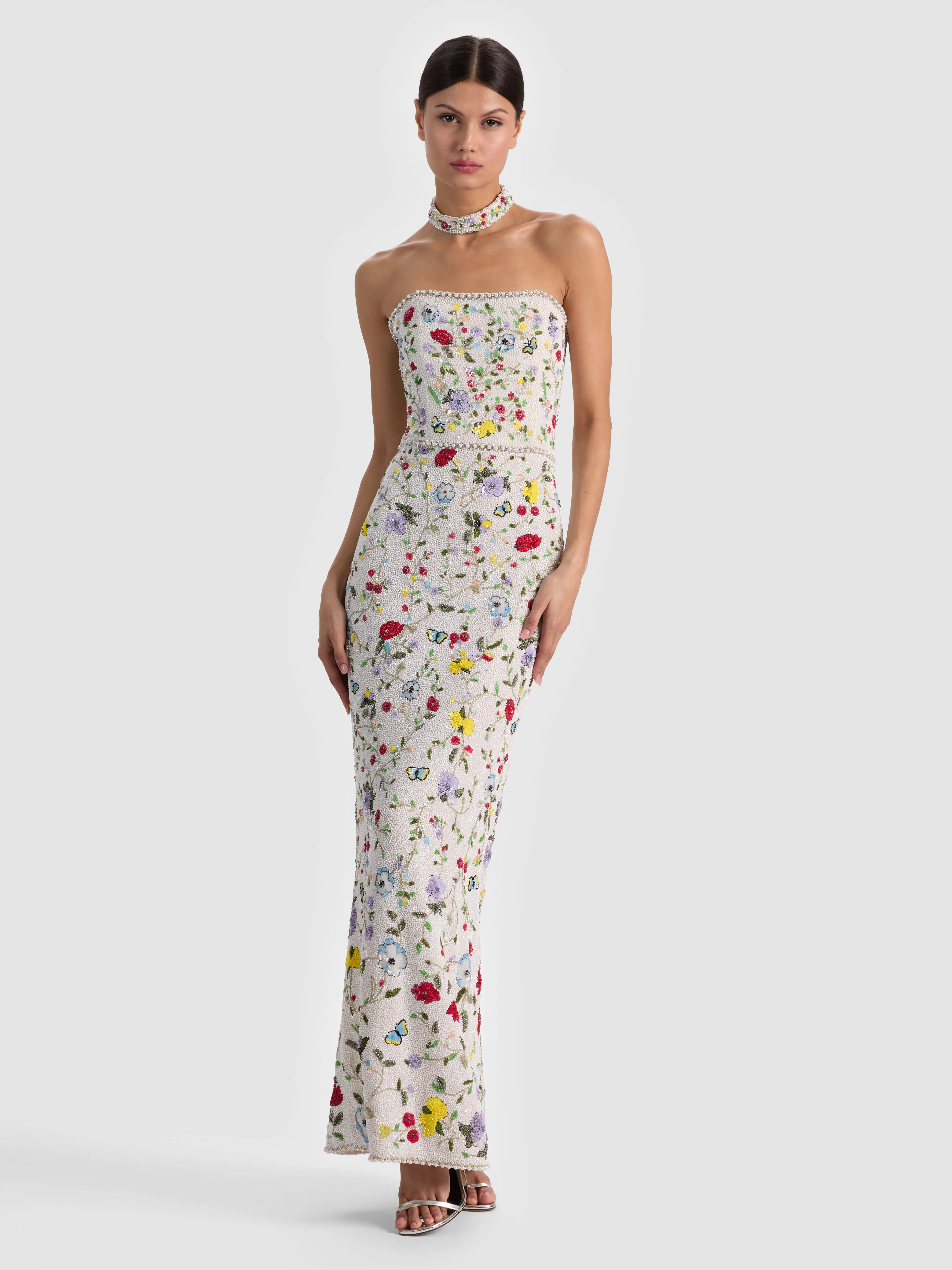 A model wearing a floor-length structured evening dress in a luxurious satin fabric, styled for a black-tie gala or formal wedding