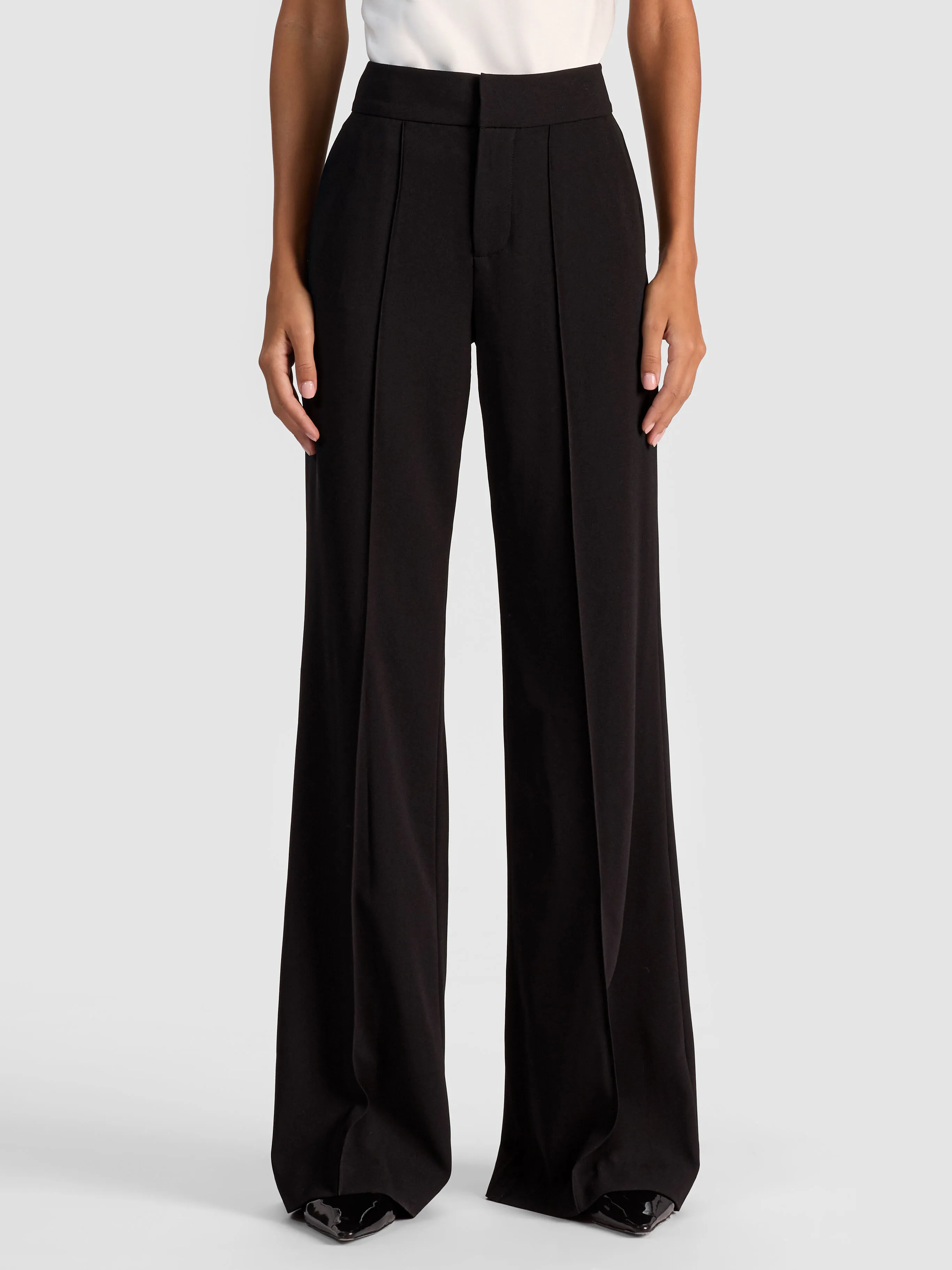 A model wearing the ALICE + OLIVIA Dylan Pant in a wide-leg suiting look, paired with a tailored blazer, showcasing the elongated and elegant silhouette.