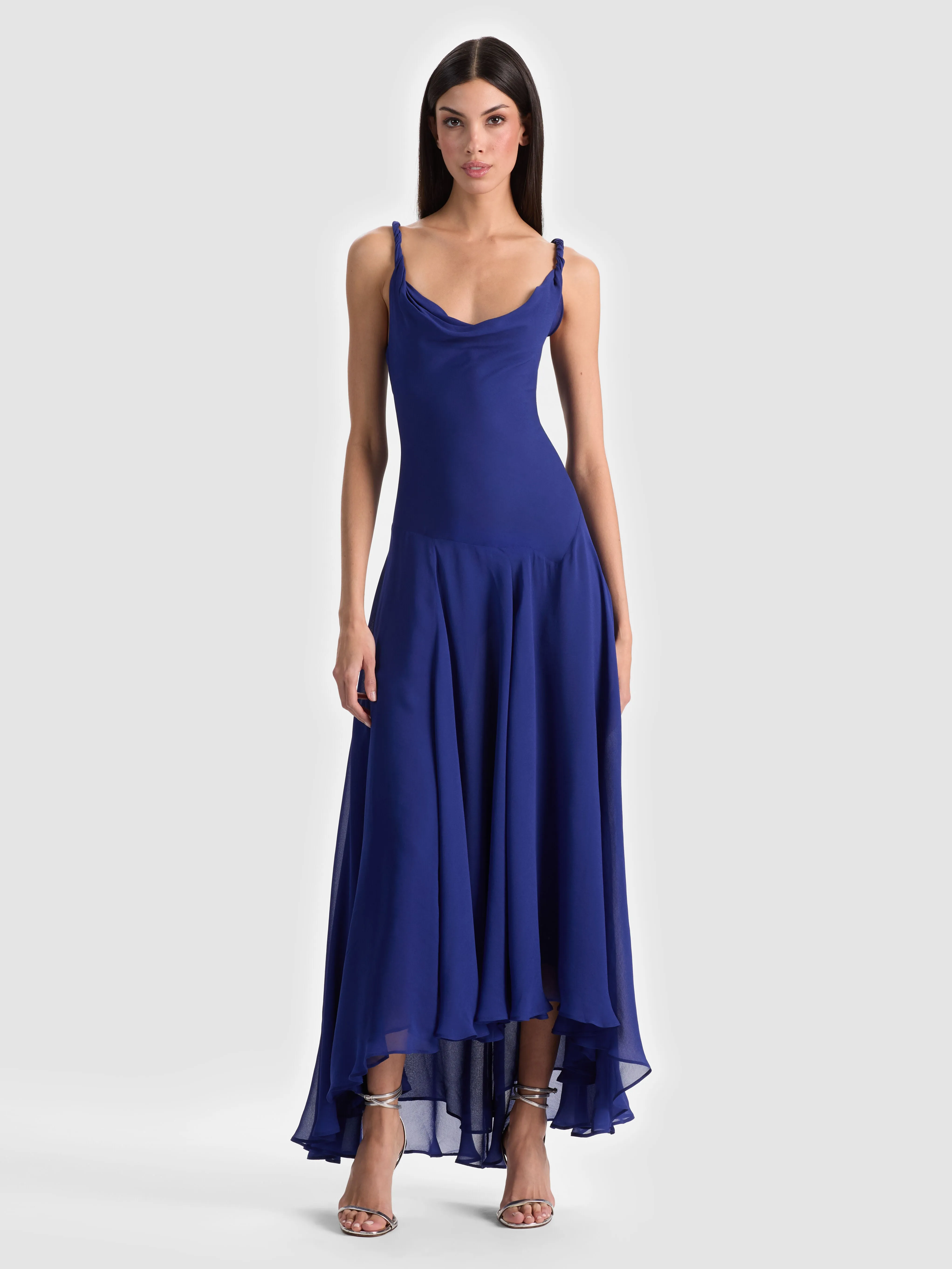ALICE + OLIVIA Sarika Maxi Slip Dress in twilight blue — a fluid viscose georgette slip silhouette with a draped cowl neckline and twisted straps, shown in a full-length editorial shot.