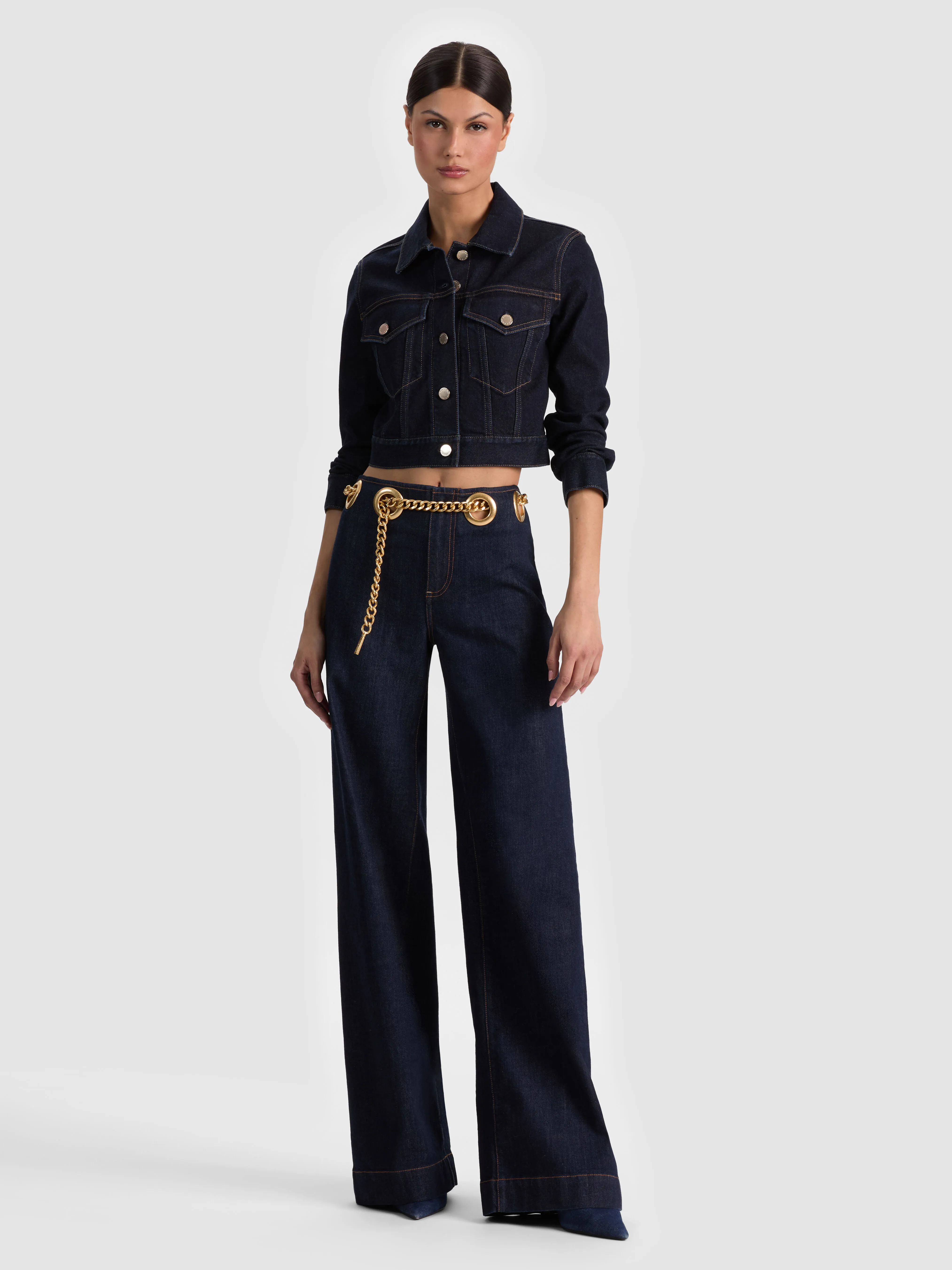 Full-body head-to-toe shot of a model wearing the ALICE + OLIVIA Chloe Denim Jacket in Dark Rinse, styled over wide-leg jeans, showing the model's face and complete outfit.