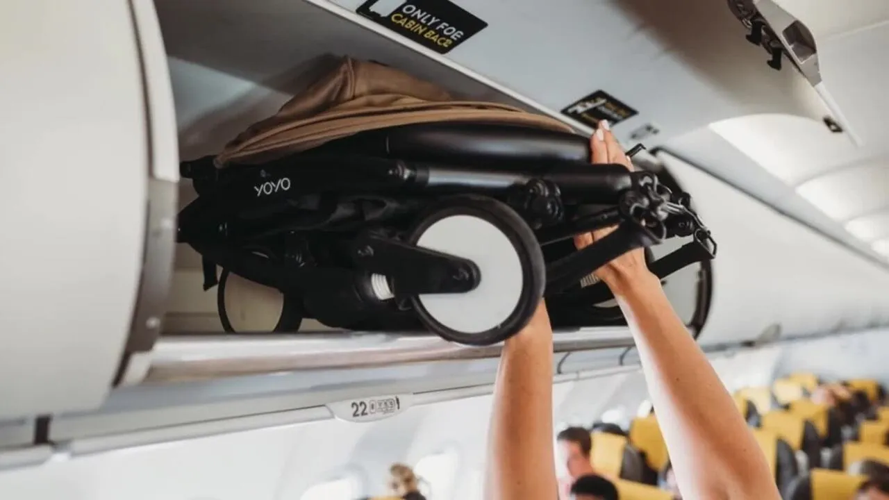 YOYO3 stroller folded to compact dimensions being placed into an aircraft overhead luggage bin with ease