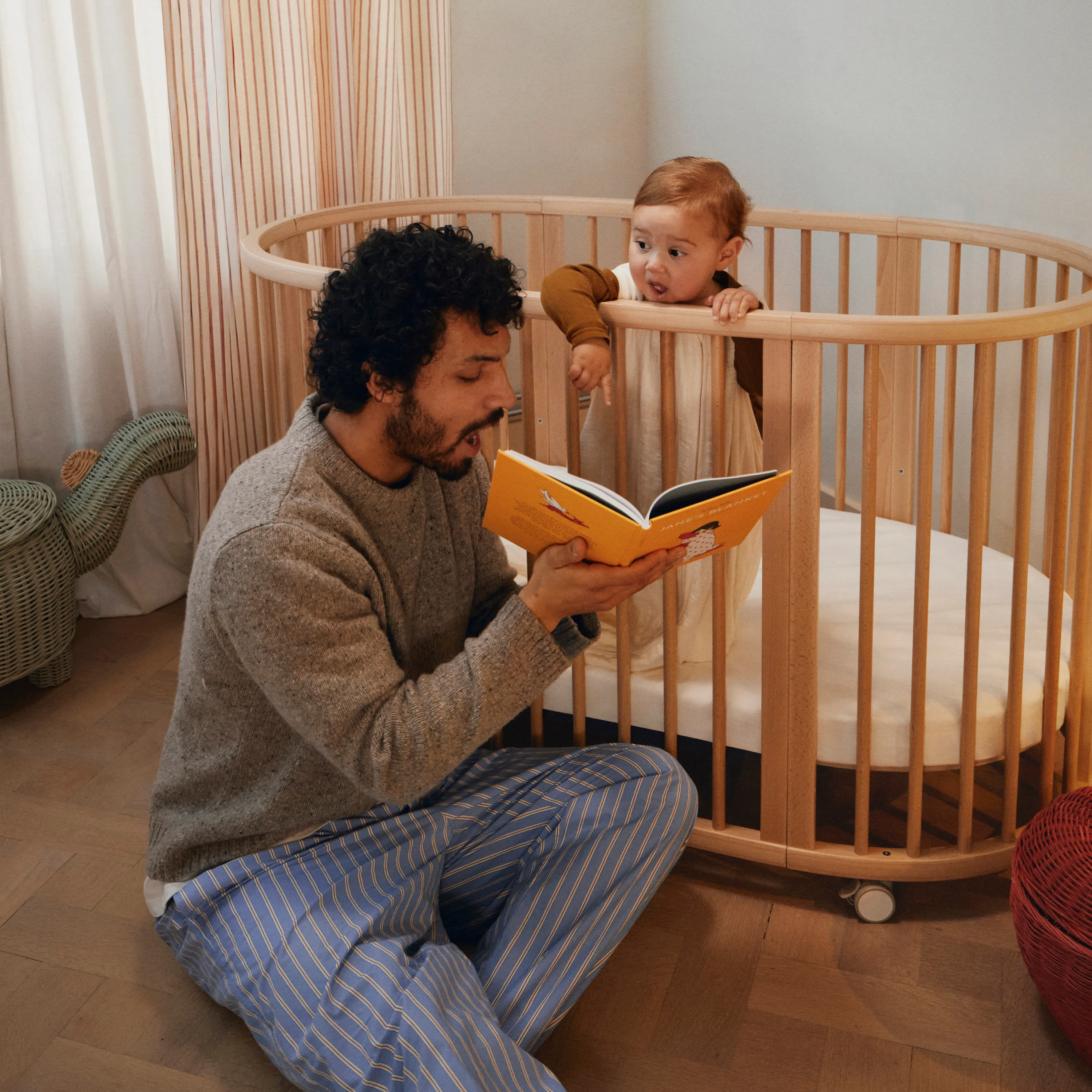 A peaceful baby sleeping in a Stokke Sleepi™ oval cot bed, showcasing the iconic Scandinavian design that grows with your child from newborn to 5 years.