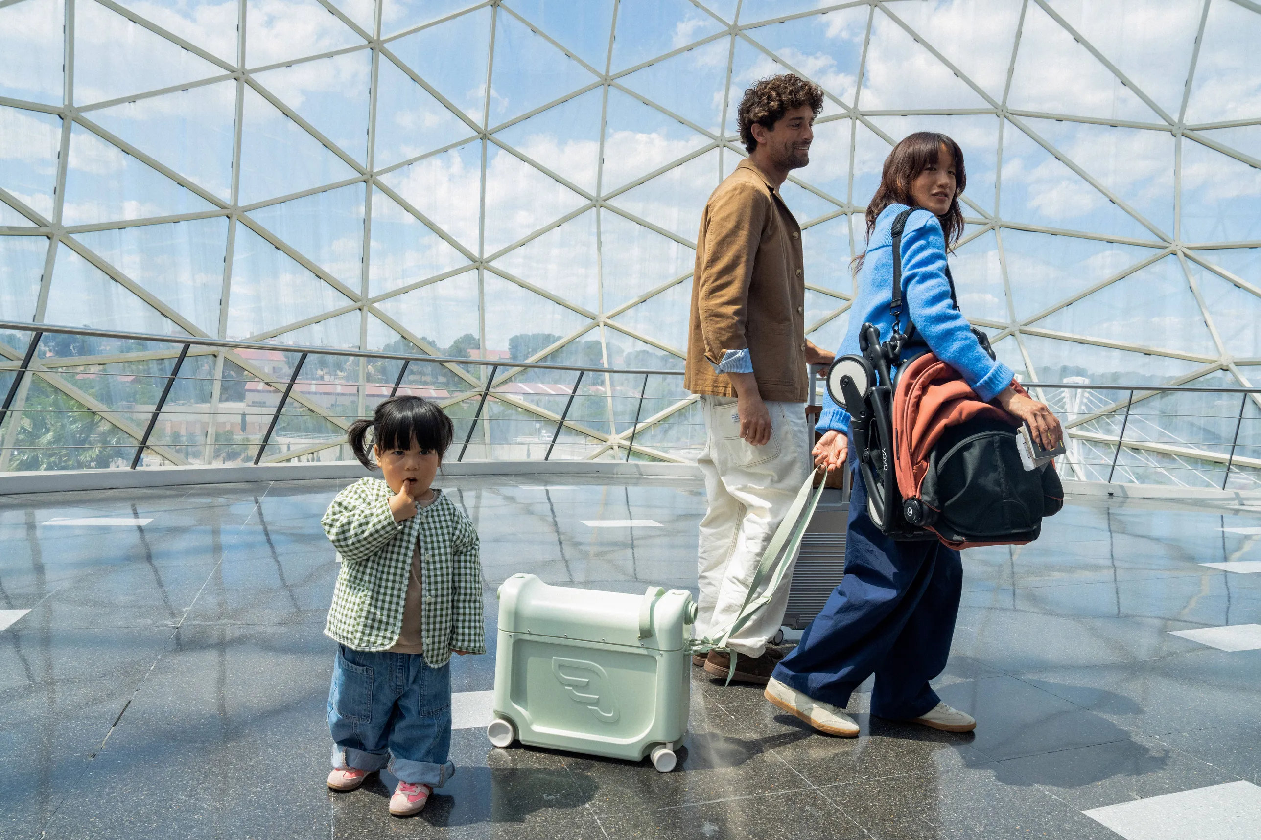 A lifestyle shot of passengers on public transit with a parent and child using a black Stokke stroller in an urban bus interior.